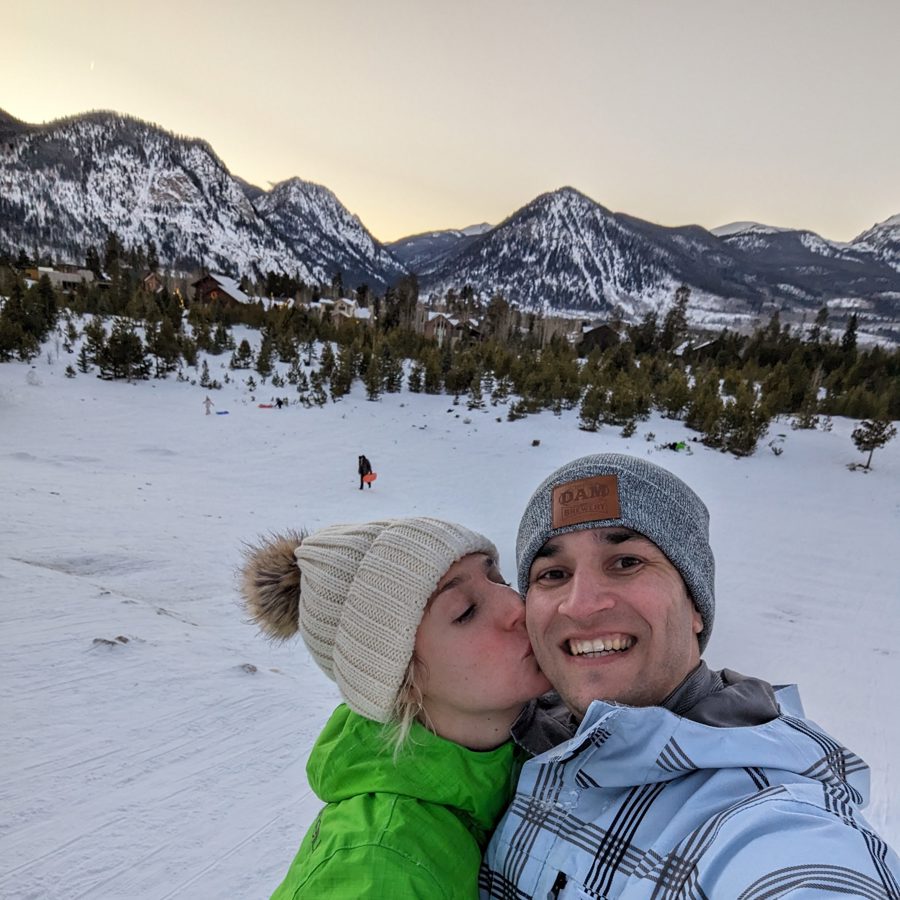 A dusk kiss on a snowy sledding hill in Colorado